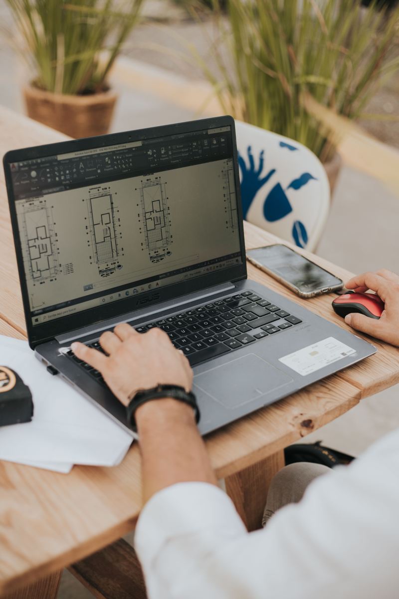 Pessoa trabalhando em plantas de arquitetura num notebook